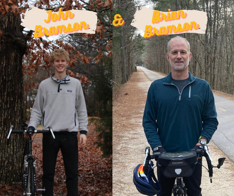 Photo of John Bramson and Brian Bramson standing with their bikes beside leafy fall roads. 