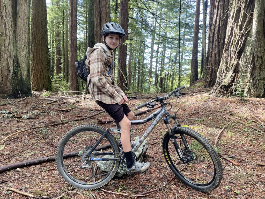 Rocco, a young Climate Rider, pausing on his mountain bike in the forests of Marin.