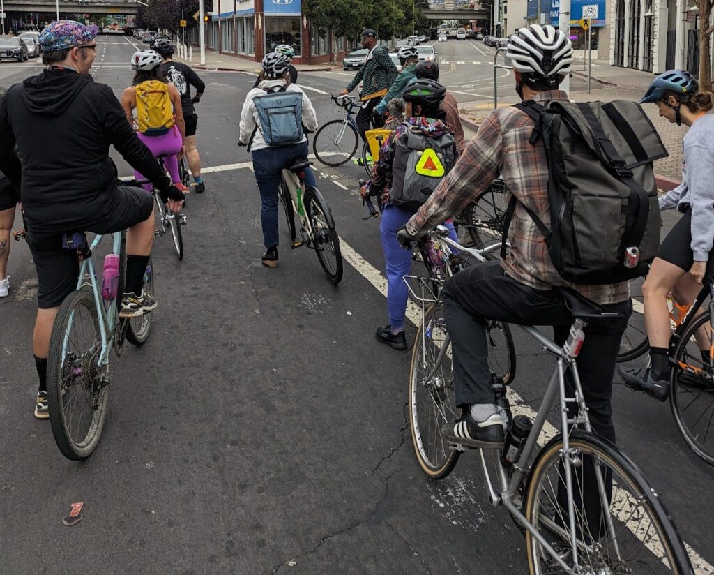 A group of cyclists pause at an intersection in the bay area.