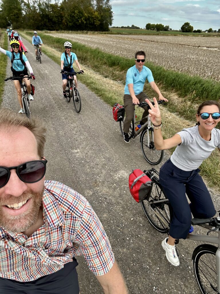 Cyclists riding in the Netherlands, with a peace sign